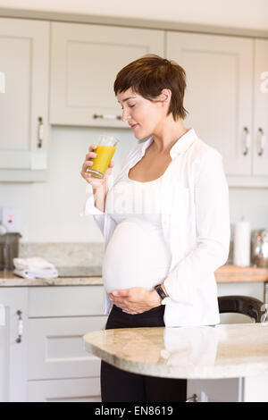 Pregnant woman having a glass of orange juice Stock Photo