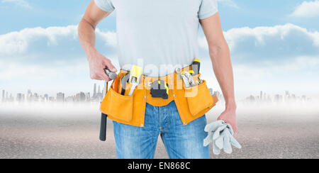 Composite image of technician holding gloves and hammer Stock Photo