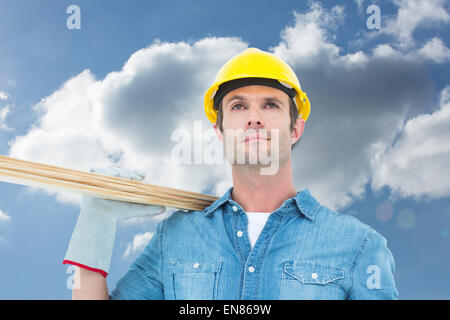 Composite image of worker carrying wooden planks Stock Photo