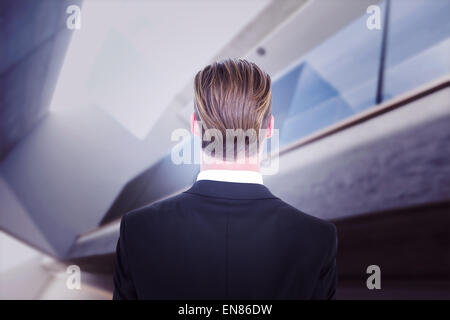 Composite image of rear view of elegant businessman in suit posing Stock Photo