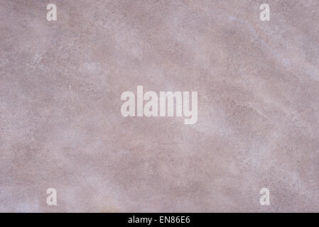Close up of the plastered surface of an coarse marsala painted wall with scratches and spots. Pastel tone for background. Stock Photo