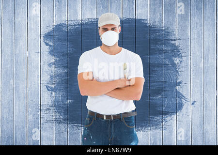 Composite image of man with paintbrush standing arms crossed by ladder Stock Photo