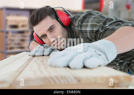 Composite image of carpenter measuring wooden plank Stock Photo