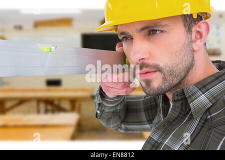 Composite image of carpenter using spirit level Stock Photo