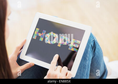 Composite image of teen using a tablet pc sitting on the floor Stock Photo