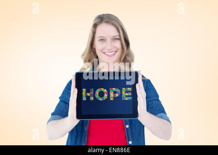 Composite image of smiling woman holding tablet pc Stock Photo