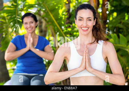 Relaxed woman and her trainer doing yoga Stock Photo