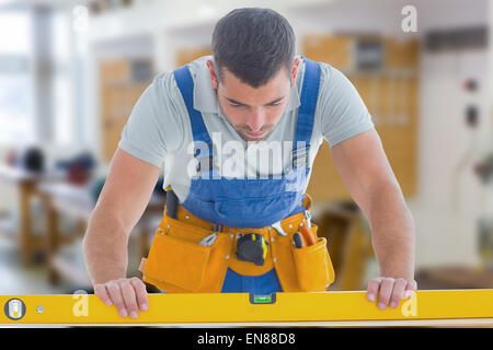 Composite image of worker using spirit level Stock Photo