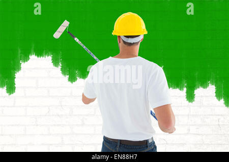 Composite image of man using paint roller Stock Photo