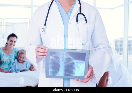 Composite image of doctor looking at xray on tablet Stock Photo