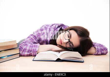 Young female student sleeping on the table with books over wihte background Stock Photo