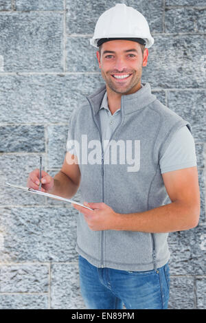 Composite image of portrait of smiling supervisor writing on clipboard Stock Photo