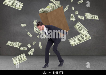 Composite image of businessman carrying bag of dollars Stock Photo