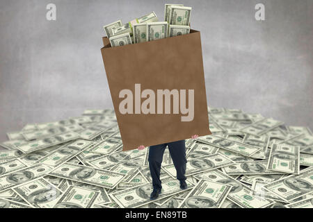 Composite image of businessman carrying bag of dollars Stock Photo