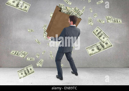 Composite image of businessman carrying bag of dollars Stock Photo