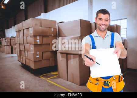 Composite image of smiling handyman giving clipboard for signature Stock Photo