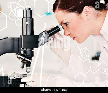 Composite image of attractive redhaired scientist looking through a microscope Stock Photo
