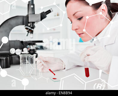 Composite image of cute redhaired female scientist doing an experiment in a lab Stock Photo