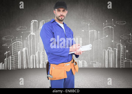 Composite image of handyman in blue overall writing on clipboard Stock Photo