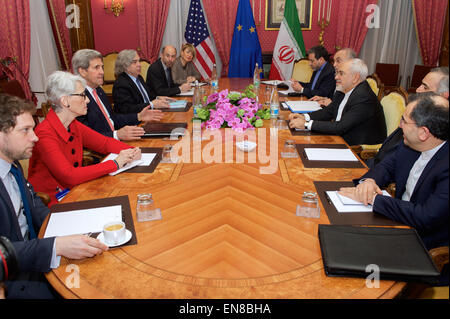 U.S. Secretary of State John Kerry - flanked by Under Secretary of State for Political Affairs Wendy Sherman, U.S. Energy Secretary Dr. Ernest Moniz, National Security Council Senior Director for Iran, Iraq, Syria and the Gulf States Robert Malley, and European Union Deputy Secretary General Helga Schmid - sits across from Iranian Foreign Minister Javad Zarif, Dr. Ali Akbar Salehi, the Vice President of Iran for Atomic Energy and President of the Atomic Energy Organization of Iran, and other advisers on March 27, 2015, in Lausanne, Switzerland, before resuming negotiations about the future of  Stock Photo