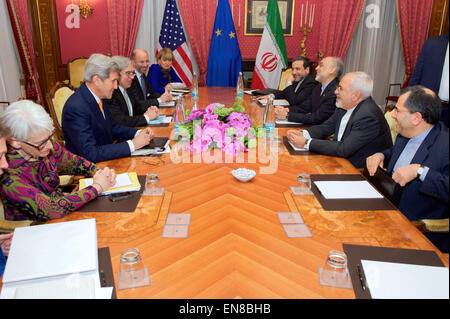 U.S. Secretary of State John Kerry - flanked by Under Secretary of State for Political Affairs Wendy Sherman, U.S. Energy Secretary Dr. Ernest Moniz, National Security Council Senior Director for Iran, Iraq, Syria and the Gulf States Robert Malley, and European Union Deputy Secretary General Helga Schmid - sits across from Iranian Foreign Minister Javad Zarif, Dr. Ali Akbar Salehi, the Vice President of Iran for Atomic Energy and President of the Atomic Energy Organization of Iran, and other advisers on March 26, 2015, in Lausanne, Switzerland, before resuming negotiations about the future of  Stock Photo