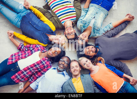 Multiethnic Group of People Holding Hands and Lying Down Stock Photo
