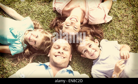 Happy family lying on the grass in a circle Stock Photo