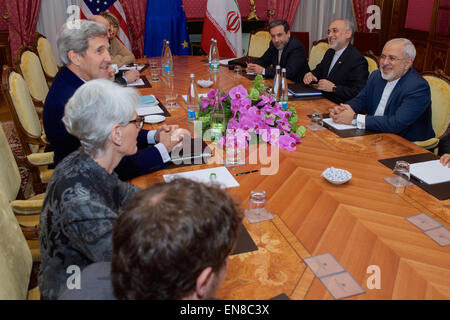 U.S. Secretary of State John Kerry - flanked by Under Secretary of State for Political Affairs Wendy Sherman, U.S. Energy Secretary Dr. Ernest Moniz, National Security Council Senior Director for Iran, Iraq, Syria and the Gulf States Robert Malley, and European Union Deputy Secretary General Helga Schmid - sits across from Iranian Foreign Minister Javad Zarif, Dr. Ali Akbar Salehi, the Vice President of Iran for Atomic Energy and President of the Atomic Energy Organization of Iran, and other advisers on March 28, 2015, in Lausanne, Switzerland, before resuming negotiations about the future of  Stock Photo