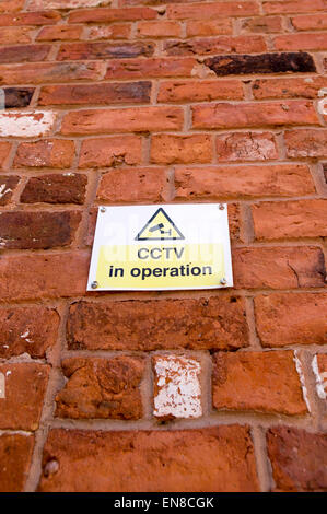 CCTV in operation sign on a red brick wall Stock Photo