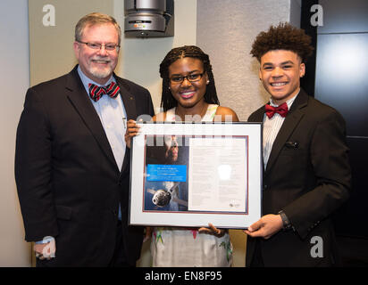 Dr. W. Michael Hawes, vice president, Orion, Lockheed Martin, left, accepts the gift of a portion of the writings of Dr. Maya Angelou that were flown aboard the Orion spacecraft during EFT-1 in December of 2014 from her great grandchildren, Caylin Johnson, center, and Brandon Johnson, right, during a ceremony on Monday, April 6, 2015 at NASA Headquarters in Washington, DC.