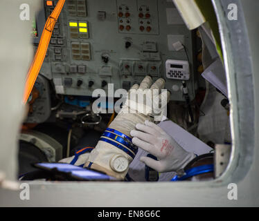 Expedition 43 NASA Astronaut Scott Kelly puts on his Russian sokol suit gloves while inside the Soyuz simulator as he and Russian Cosmonauts Gennady Padalka and Mikhail Kornienko of the Russian Federal Space Agency (Roscosmos) participate in their second day of qualification exams Thursday, March 5, 2015 at the Gagarin Cosmonaut Training Center (GCTC) Soyuz training facility in Star City, Russia. The trio is preparing for launch to the International Space Station in their Soyuz TMA-16M spacecraft from the Baikonur Cosmodrome in Kazakhstan March 28, Kazakh time. As the one-year crew, Kelly and  Stock Photo
