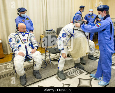 Expedition 43 NASA Astronaut Scott Kelly, left, watches as Russian Cosmonaut Gennady Padalka of the Russian Federal Space Agency (Roscosmos) dons his Russian sokol suit ahead of their launch onboard the Soyuz TMA-16M spacecraft to the International Space Station with fellow crew mate, Russian Cosmonaut Mikhail Kornienko Friday, March 27, 2015 in Baikonor, Kazakhstan. As the one-year crew, Kelly and Kornienko will return to Earth on Soyuz TMA-18M in March 2016.   (NASA/GCTC/Andrey Shelepin) Stock Photo