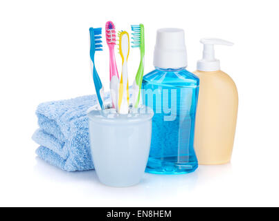 Four colorful toothbrushes, cosmetics bottles and towel. Isolated on white background Stock Photo