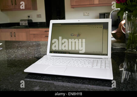laptop in the kitchen with google search screen working from home in the uk Stock Photo