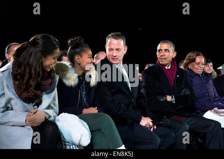 President Barack Obama, seated with daughters Malia and Sasha, Tom Hanks and Marian Robinson, attends the National Christmas Tree lighting ceremony on the Ellipse in Washington, D.C., Dec. 4, 2014. Stock Photo