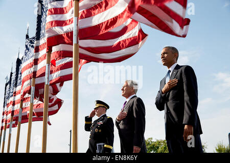 President Barack Obama, Defense Secretary Chuck Hagel, and Gen. Martin Dempsey, Chairman of the Joint Chiefs of Staff, listen to the national anthem during the September 11th Observance Ceremony at the Pentagon Memorial in Arlington, Va., Sept. 11, 2014. Stock Photo