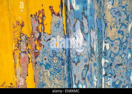 Close-up of yellow and blue metal texture with paint and rust on the side of a boat Stock Photo