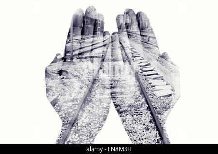 double exposure of the palms of a man put together and a railway, in black and white Stock Photo