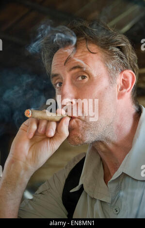 Vertical portrait of a European man smoking a cigar. Stock Photo