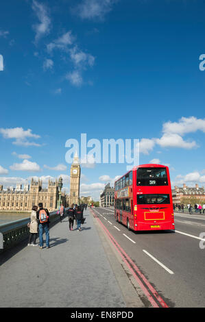 LONDON, UK - APRIL 27, 2015: Pedestrians pass bus on Westminster Bridge in front of Big Ben and Houses of Parliament. Stock Photo