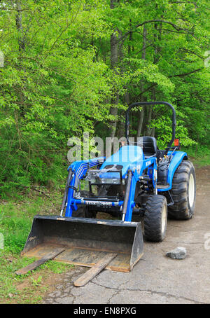 Blue Bush Hog TC400 tractor along a forest road Stock Photo