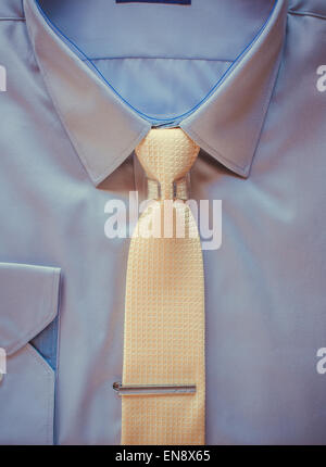 Blue cotton shirt and yellow tie with clip close up Stock Photo