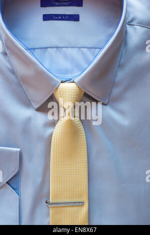 Blue cotton shirt and yellow tie with clip close up Stock Photo