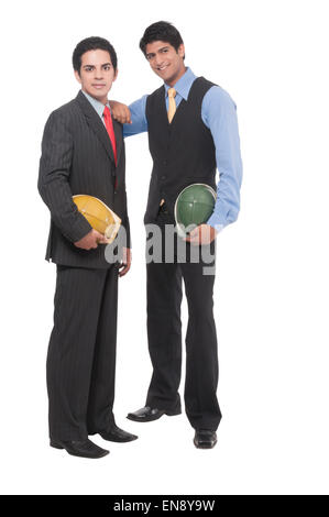Two asian professional men standing together with helmets in their hands Stock Photo
