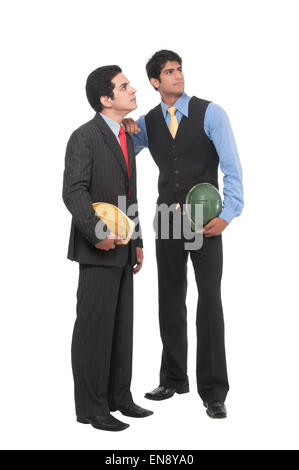 Two asian professional men standing , working together with helmets in their hands Stock Photo