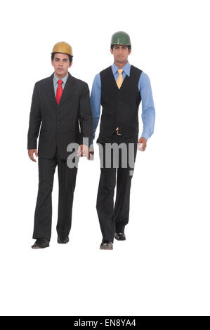 Two asian professional men walking together, wearing helmets Stock Photo