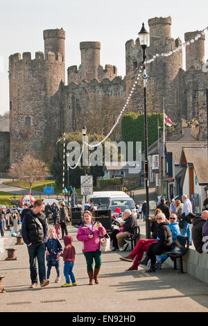 Visitors enjoying the Spring sunshine on Conwy Quay, with Conwy Castle in the background Stock Photo