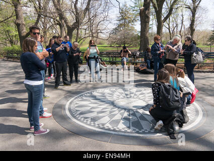 Group of people posing for photograph at the John Lennon, Strawberry Fields, Imagine memorial Central Park, NYC, USA Stock Photo