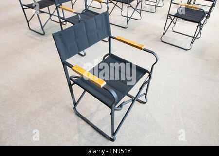 Auditorium area with empty black folding chairs Stock Photo