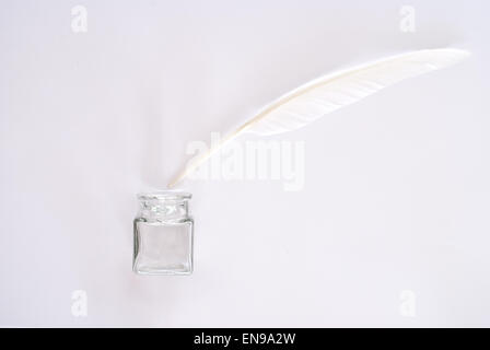 White feather on white background and ink pot Stock Photo